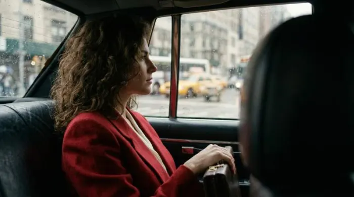 Woman in red 1980s power blazer with pearls and briefcase Woman in red 1980s power blazer with pearls and briefcase