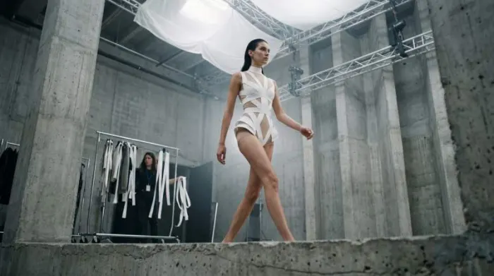 Model wearing futuristic tape-inspired geometric fashion design in editorial studio