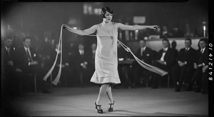 1920s flapper dancing with long sautoir necklace and fringe dress