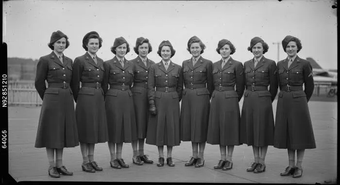 Woman in a 1940s wide-shouldered jacket with prominent padded shoulders, embodying wartime power and authority.