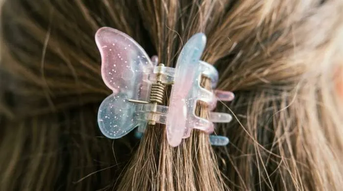Closeup of butterfly clip hinge and snap-open mechanism gripping hair strands